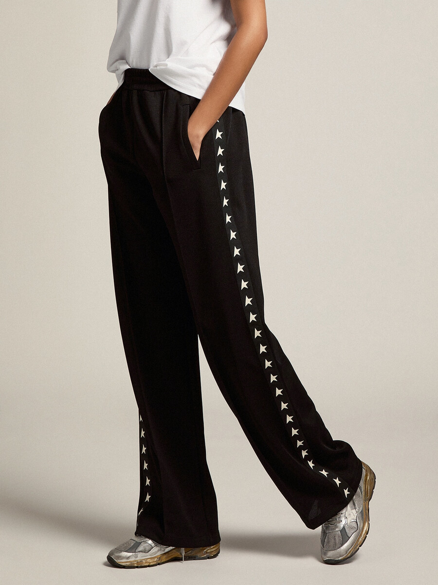 calça de moletom feminina preta com estrelas brancas nas laterais.