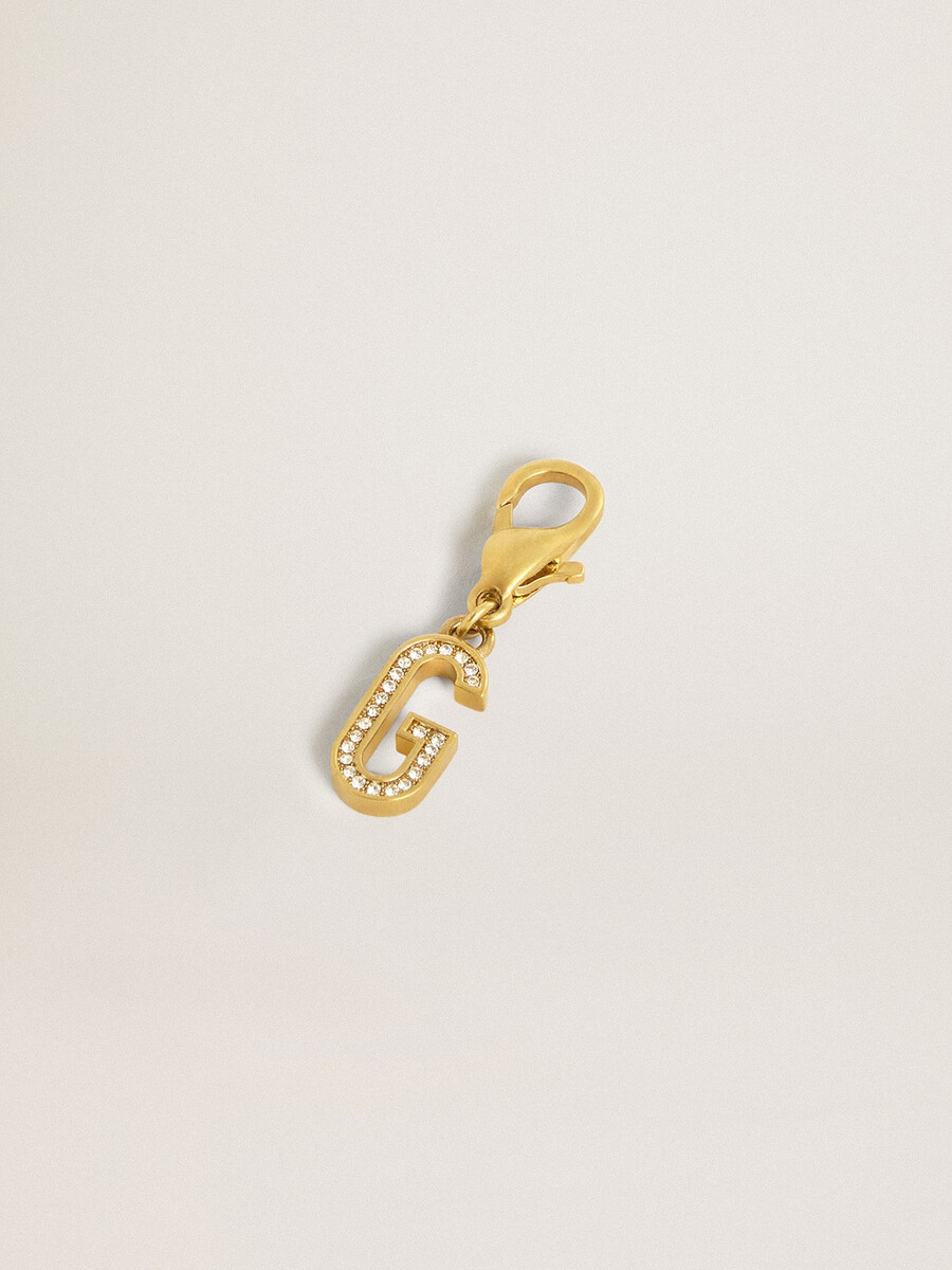 pingente com a letra g em latão dourado com cristais.