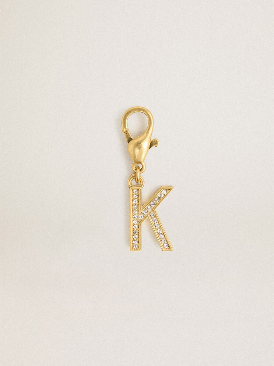 pingente com a letra k em latão dourado com cristais.