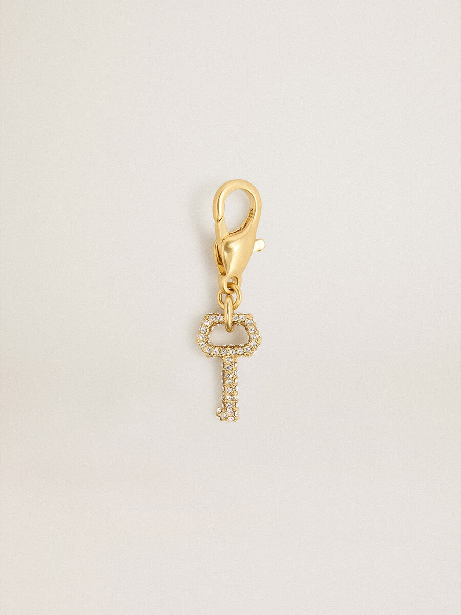 pingente em forma de chave em latão dourado com cristais.