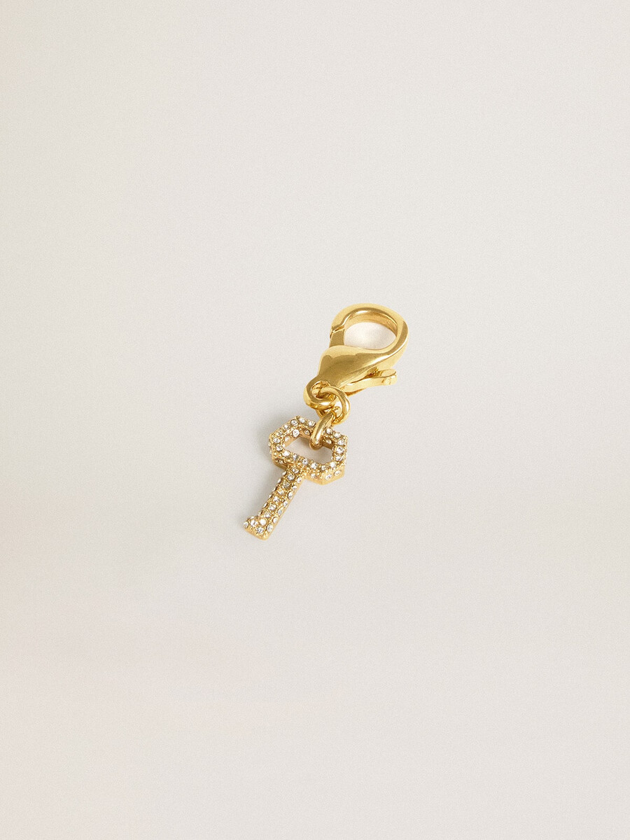 pingente em forma de chave em latão dourado com cristais.