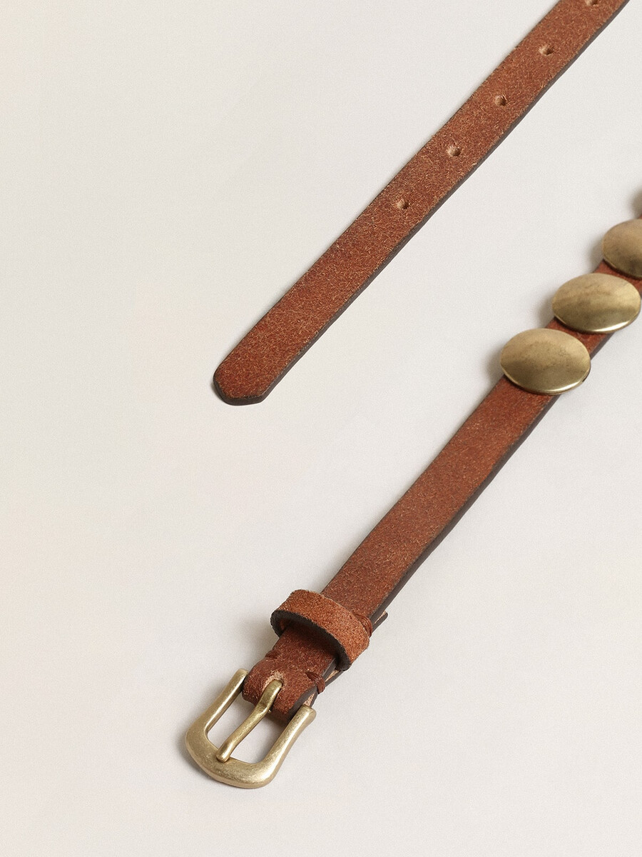 cinto trinidad em couro envelhecido cor castanho com tachas douradas grandes.