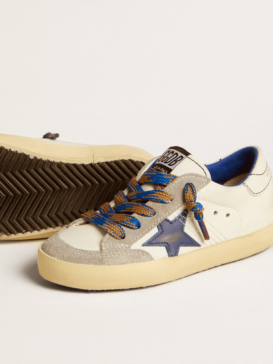 super-star junior com estrela de couro azul e detalhes em camurça cinza-gelo.