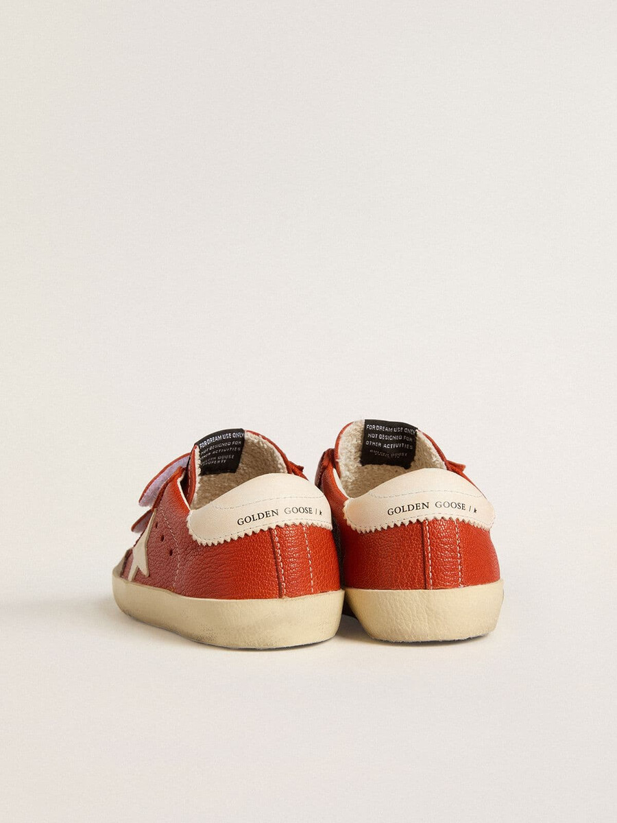 teen old school em napa laranja com estrela branca e detalhe de couro creme no calcanhar.