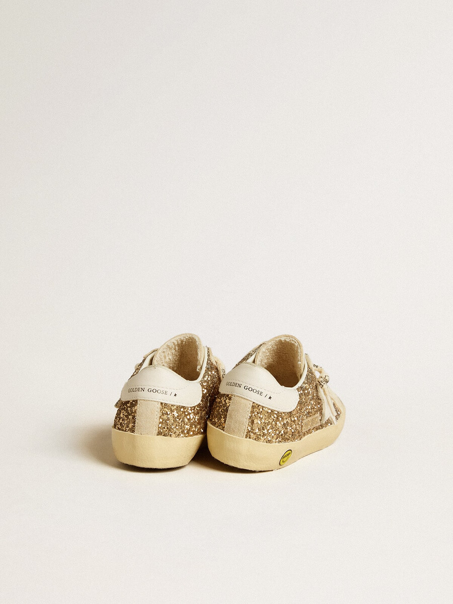 super-star junior em glitter dourado com estrela de couro branco e detalhe no calcanhar.