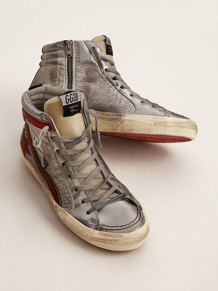 chinelo feminino com cabedal em couro metálico prateado e detalhes em couro metálico vermelho.