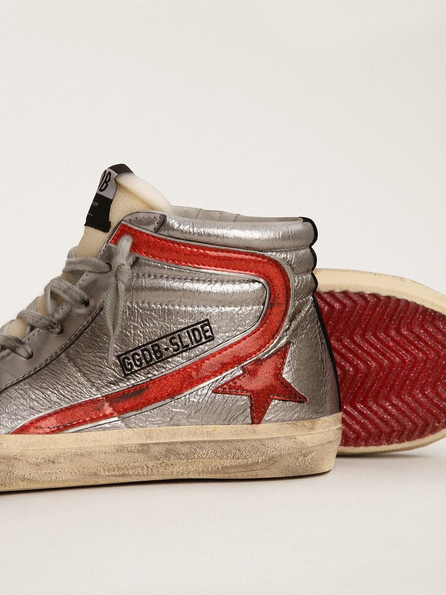chinelo feminino com cabedal em couro metálico prateado e detalhes em couro metálico vermelho.