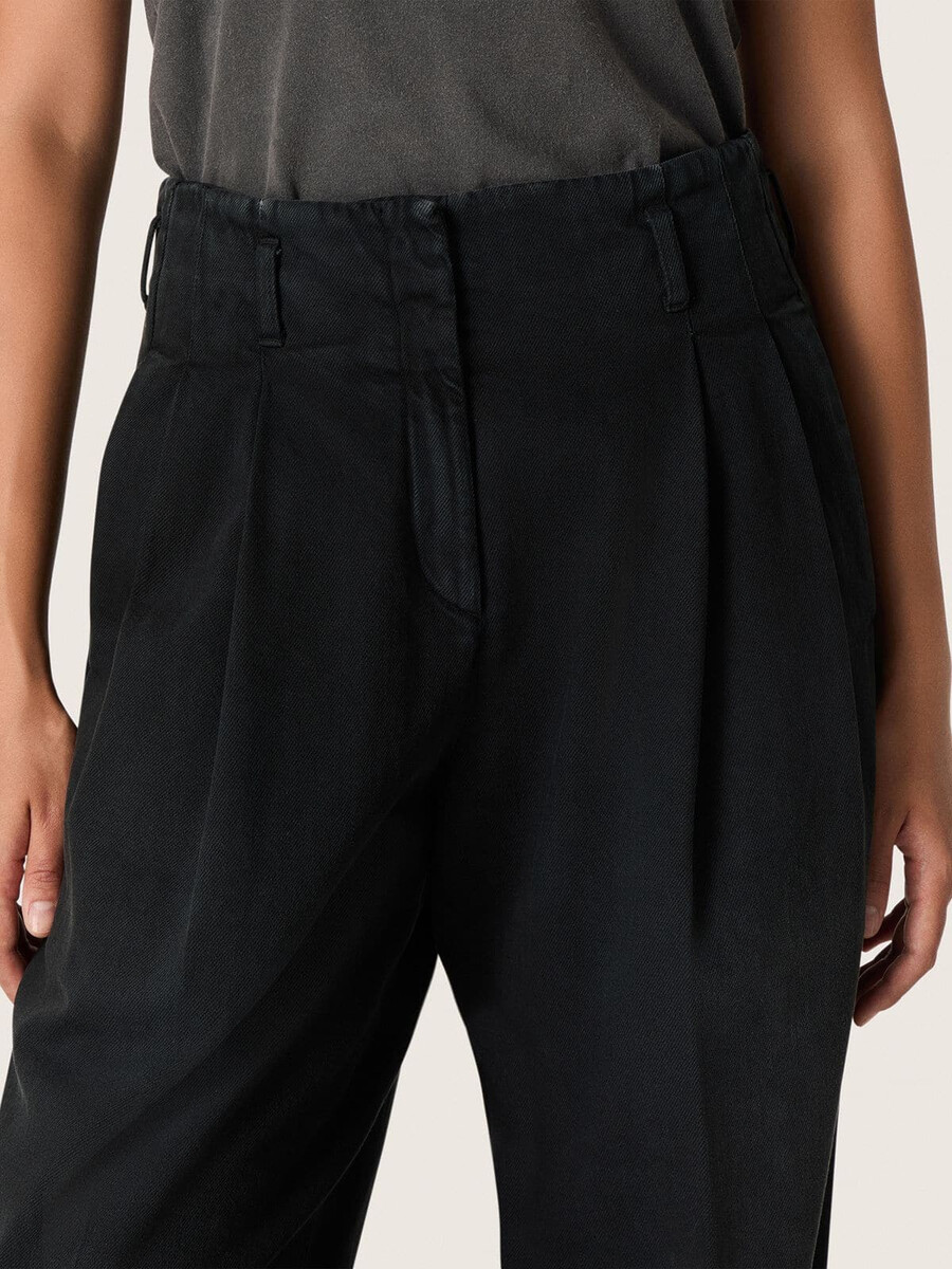 calça feminina em denim de algodão preto com acabamento desgastado.
