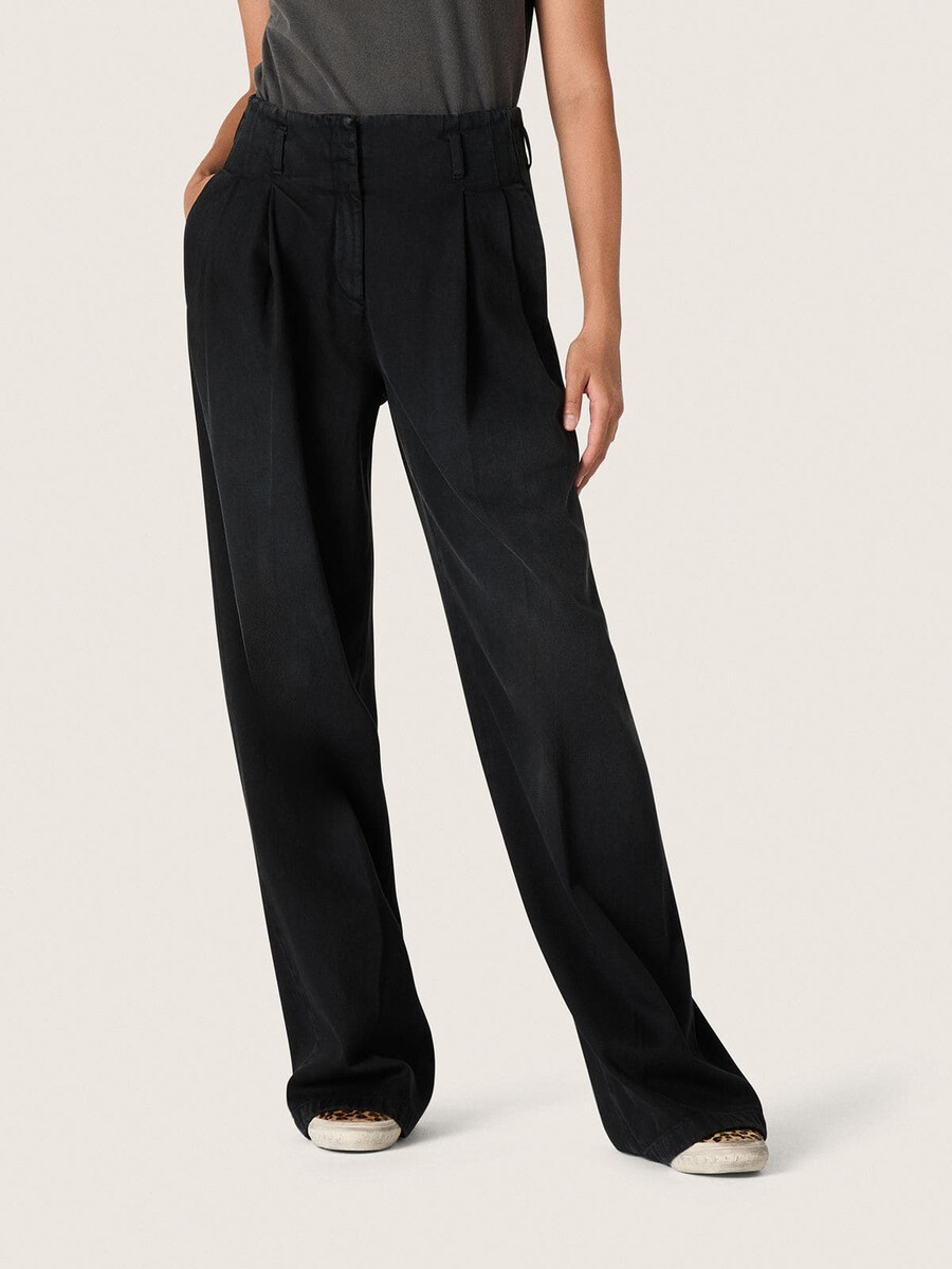 calça feminina em denim de algodão preto com acabamento desgastado.