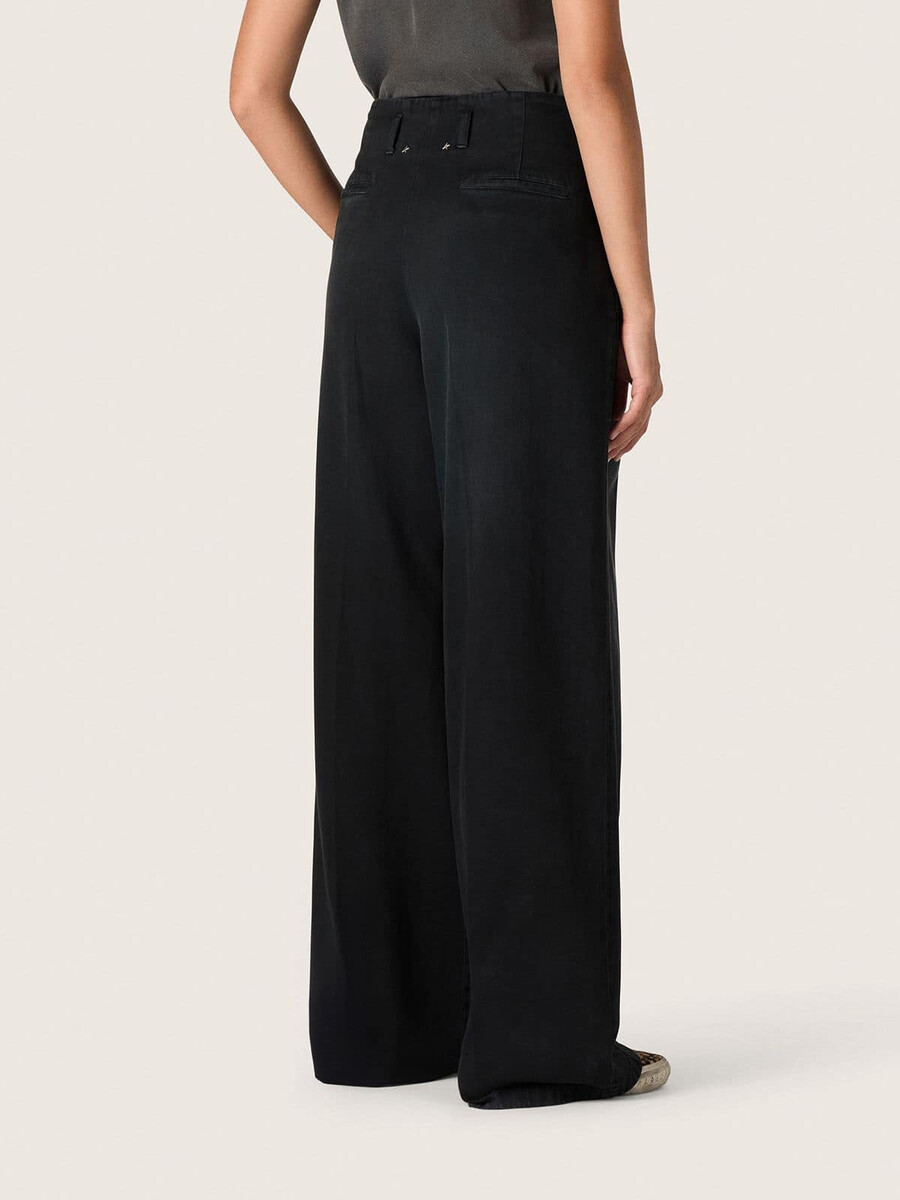 calça feminina em denim de algodão preto com acabamento desgastado.