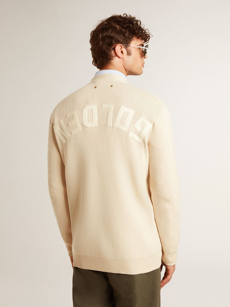 cardigã masculino bege com a inscrição golden nas costas.