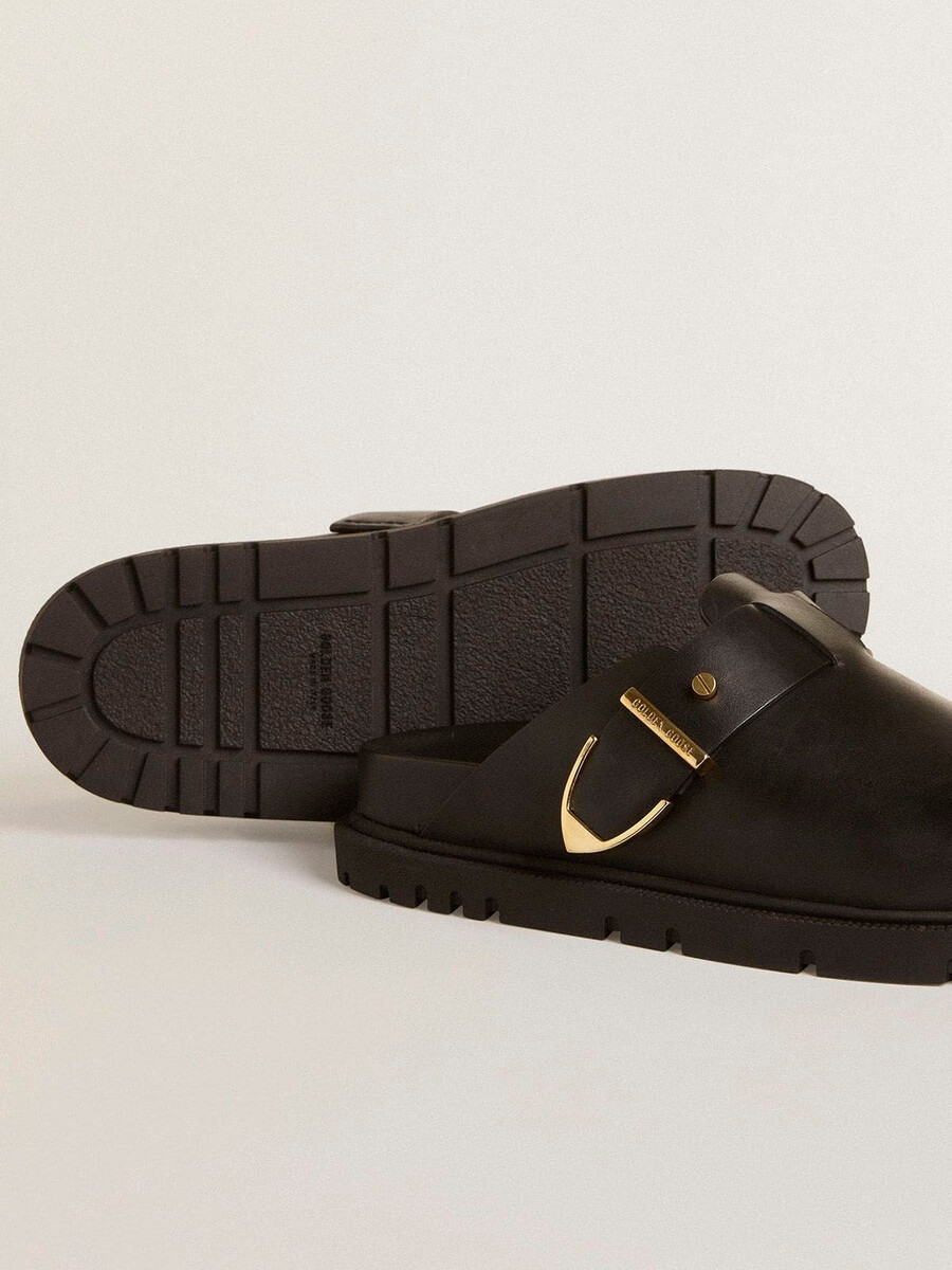 sapatilha feminina lucy sabot em couro preto brilhante com fivela de metal dourado.