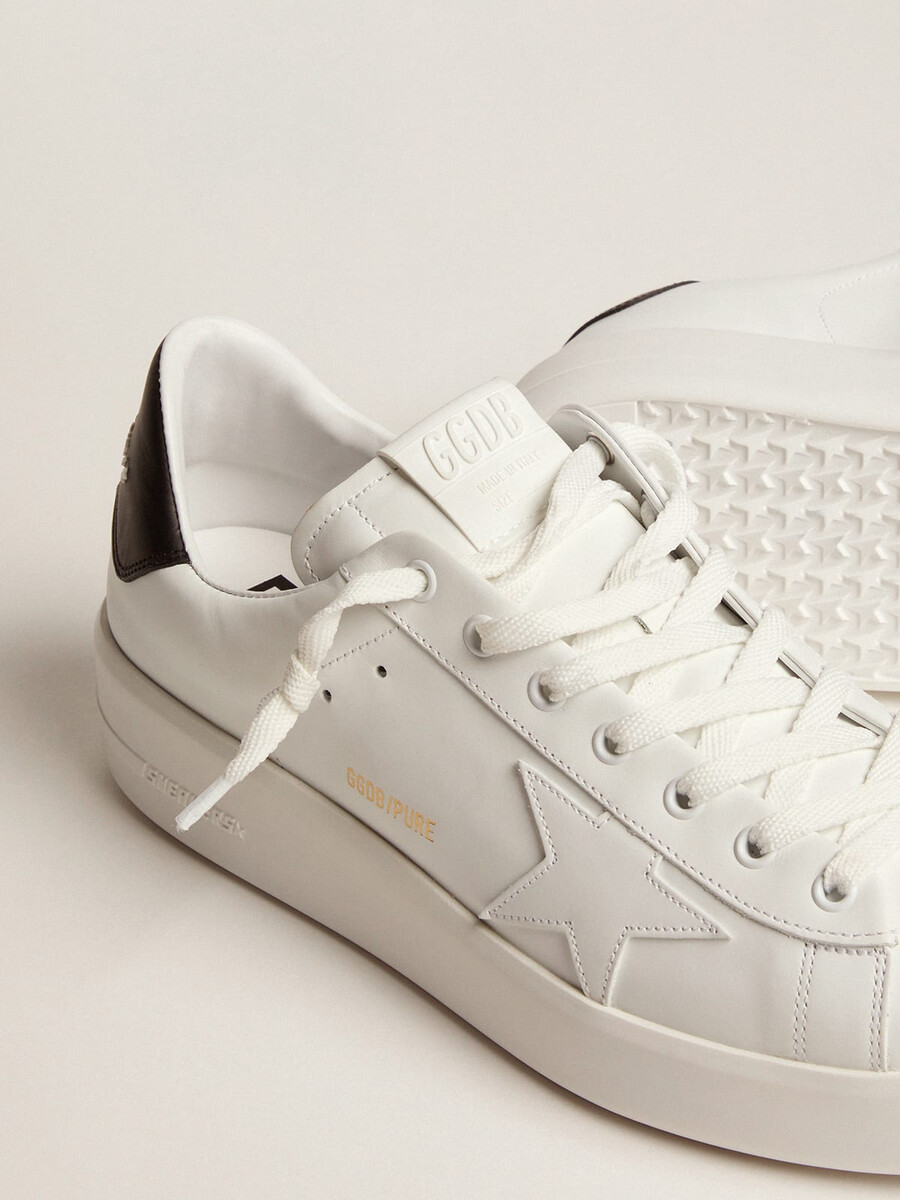 tênis masculino purestar com estrela de couro e detalhe de couro preto no calcanhar.