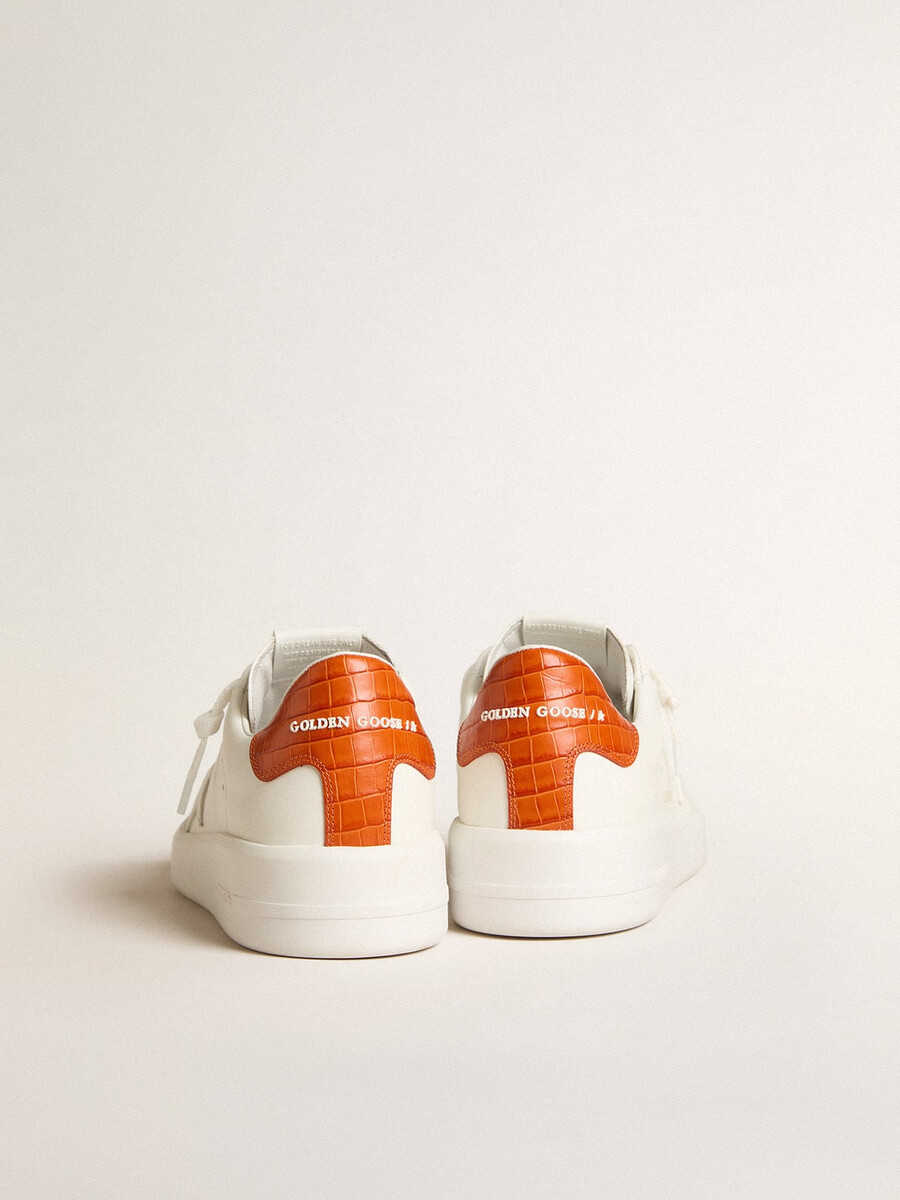 tênis masculino purestar com estrela de couro branca e detalhe laranja no calcanhar.