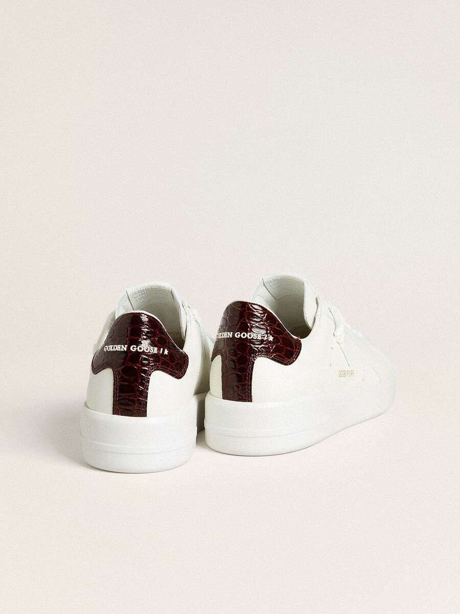 tênis masculino purestar com estrela de couro branco e detalhe de couro com estampa de crocodilo na cor bordô no calcanhar.