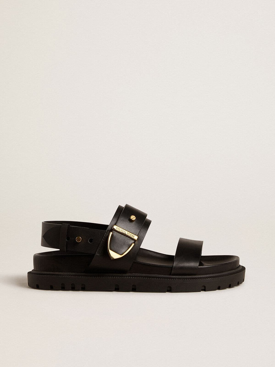 sandália feminina lucy em couro preto brilhante com fivela de metal dourado.