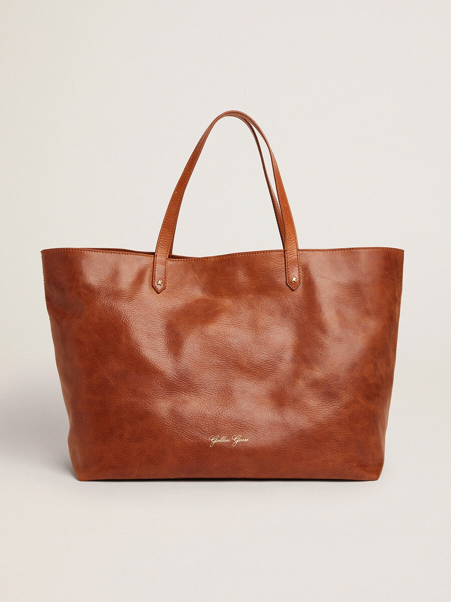 bolsa pasadena em couro martelado brilhante na cor bege com logotipo dourado na parte frontal.