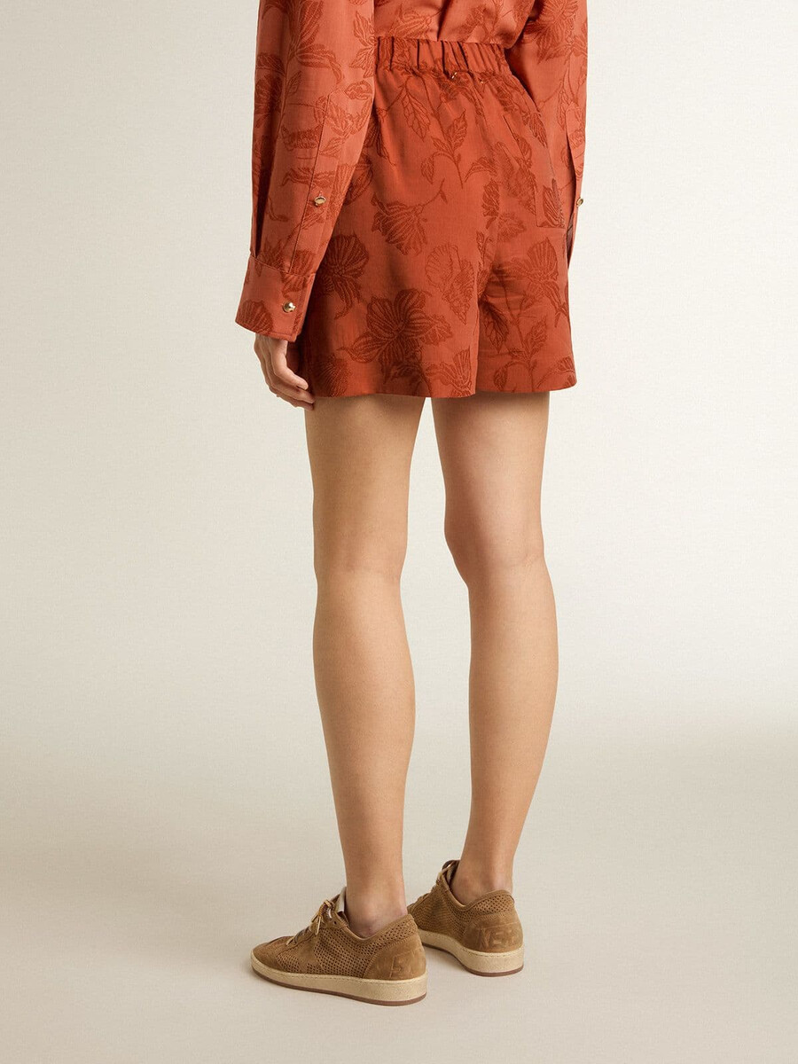 calções femininos em jacquard vermelho-tijolo com estampa floral náutica.