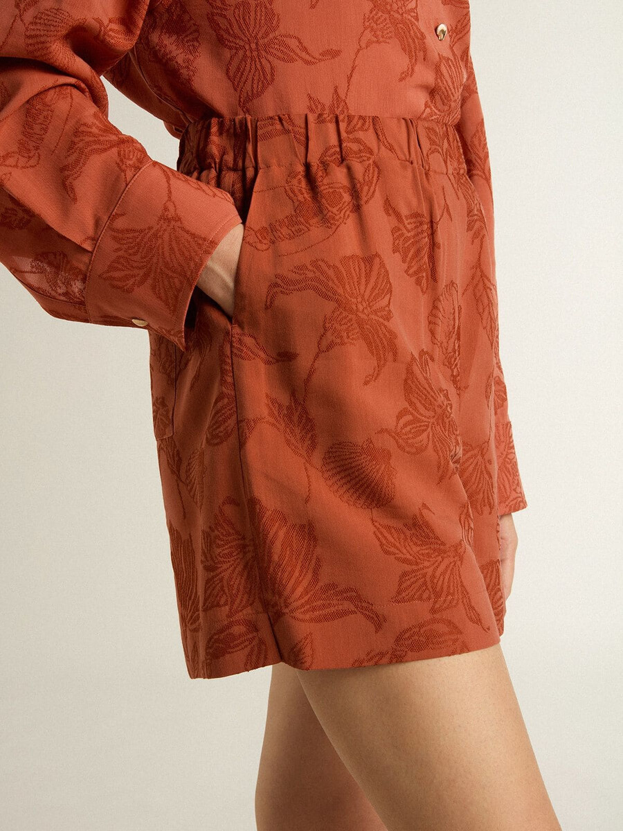 calções femininos em jacquard vermelho-tijolo com estampa floral náutica.