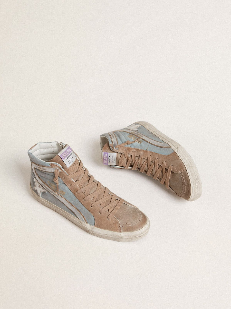 chinelo masculino em lona azul-clara com detalhes em couro metálico prateado.