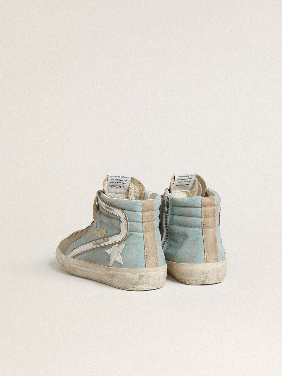 chinelo masculino em lona azul-clara com detalhes em couro metálico prateado.