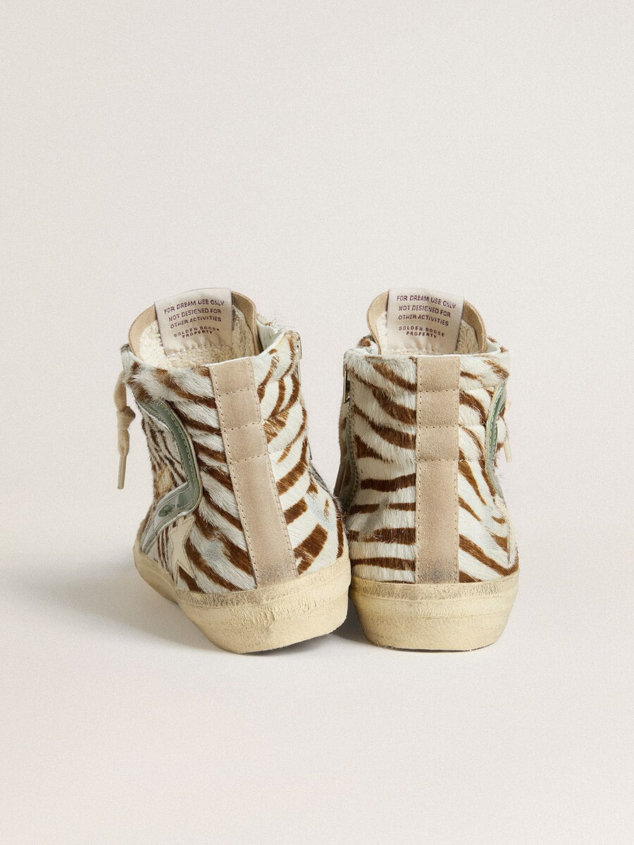 sandália feminina em pele de pônei com estampa de zebra e detalhe em couro laminado verde.