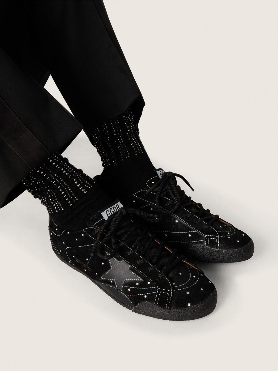 meias pretas com detalhes desgastados e strass.