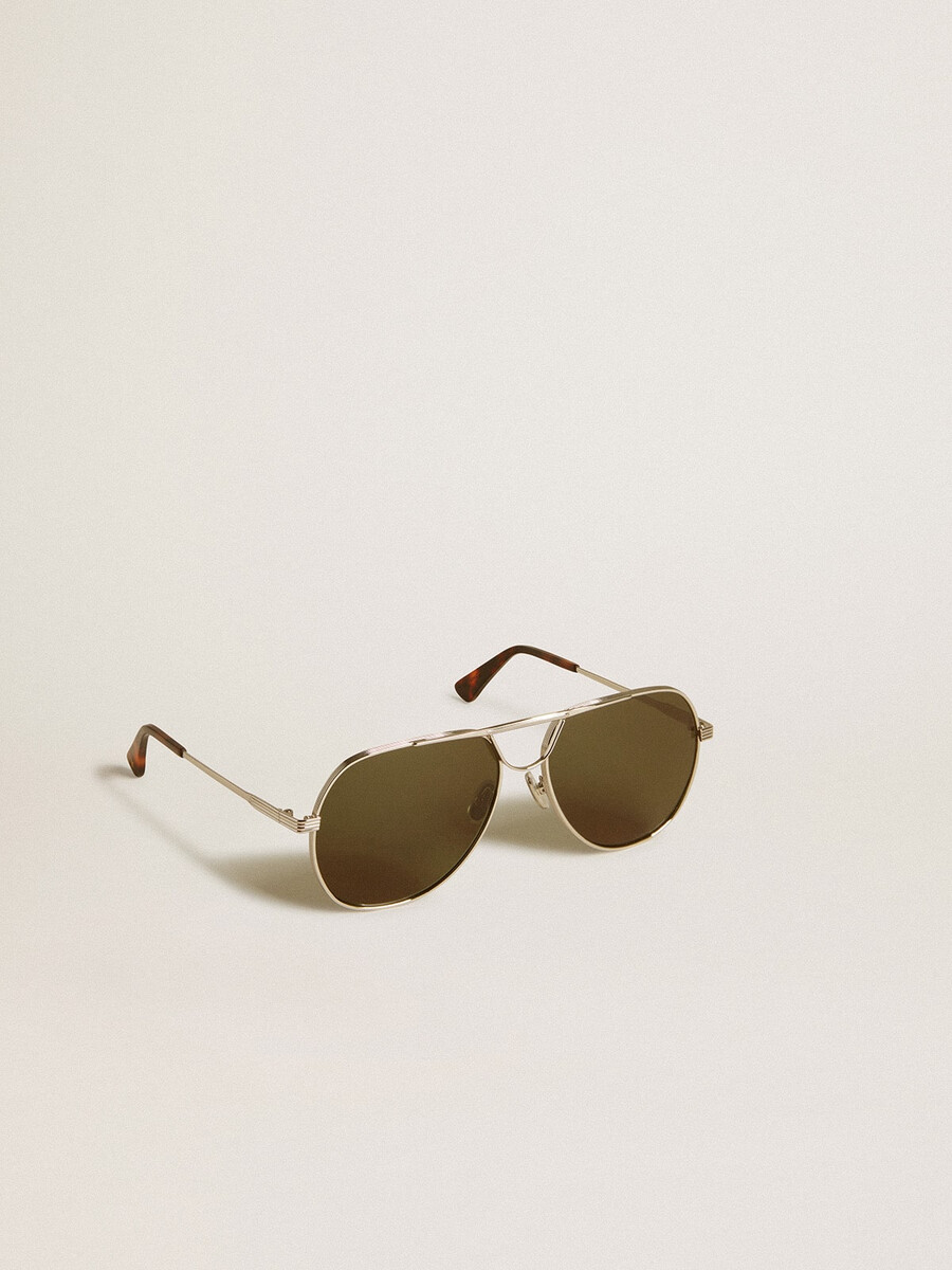 Óculos de sol estilo aviador com armação prateada e lentes verdes.