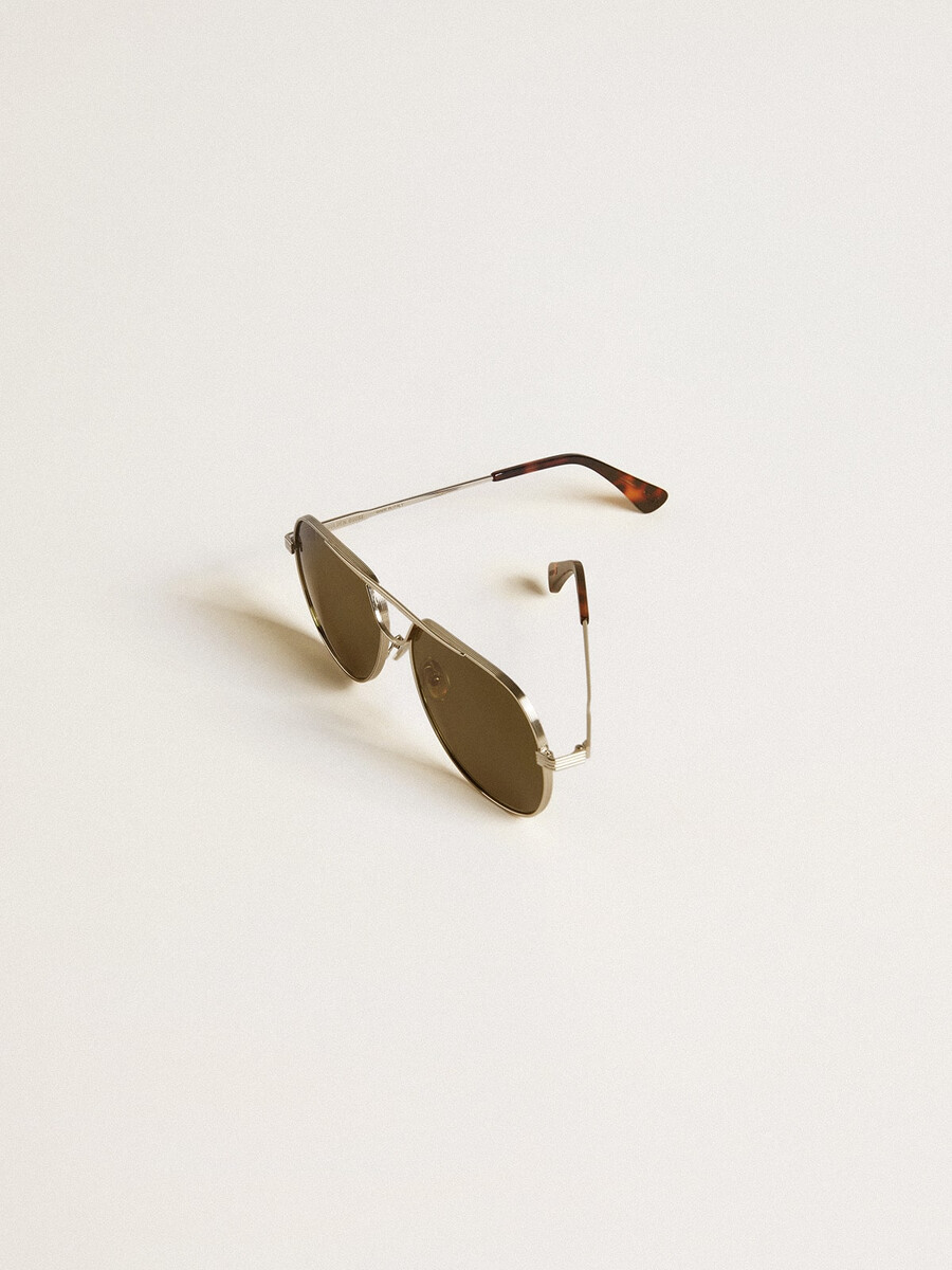 Óculos de sol estilo aviador com armação prateada e lentes verdes.