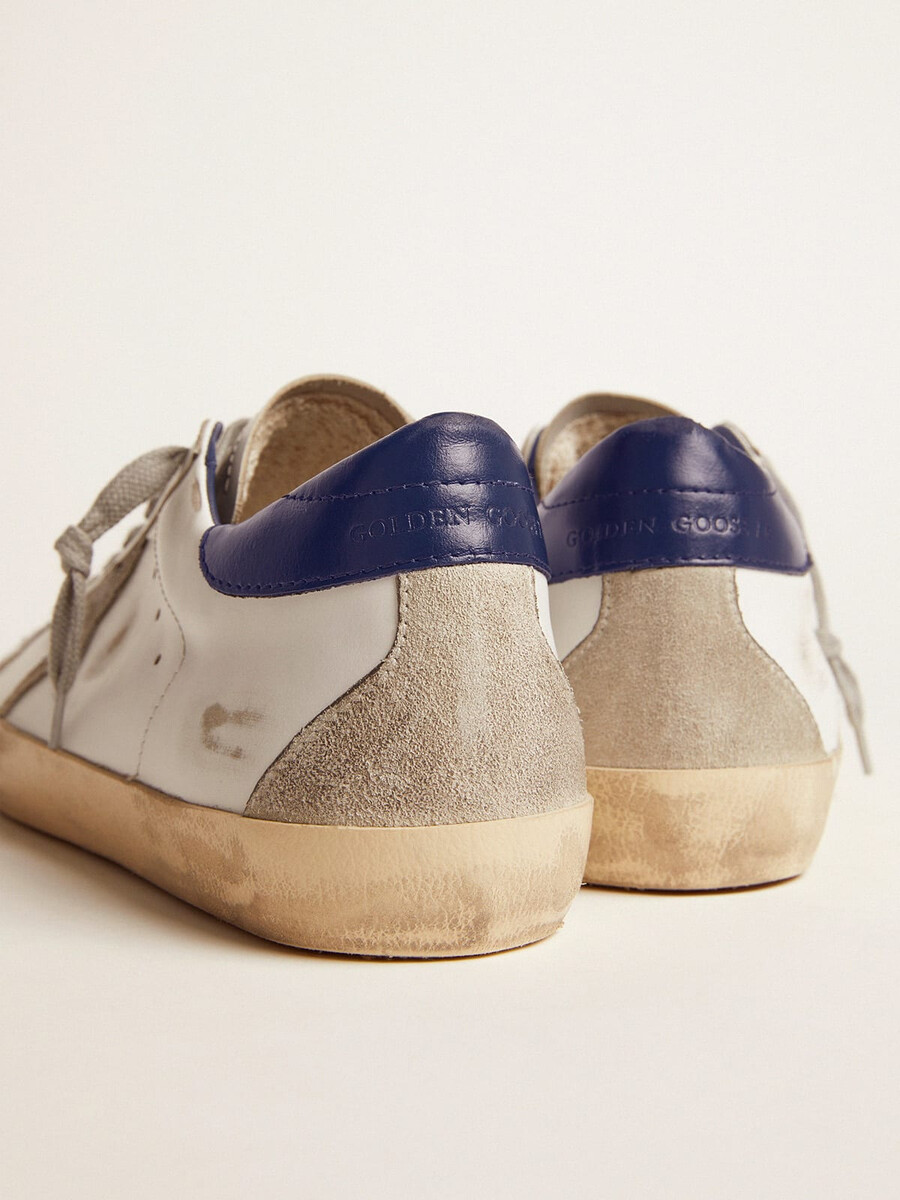 tênis masculino super-star com estrela de camurça e detalhe azul no calcanhar.