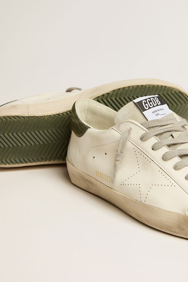 tênis masculino super-star de base biológica com estrela perfurada e detalhe verde no calcanhar.