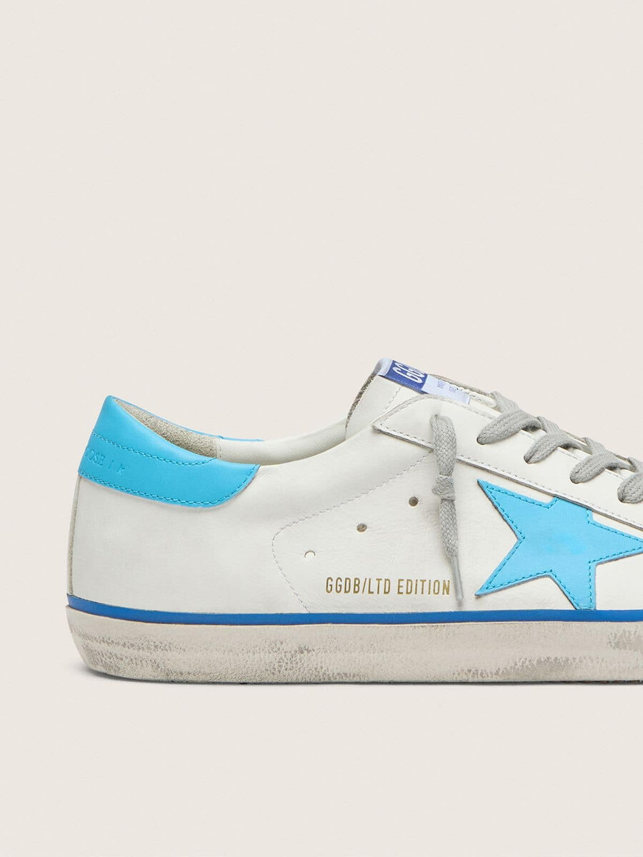 tênis masculino super-star ltd em couro branco com estrela em couro azul claro e detalhe no calcanhar.