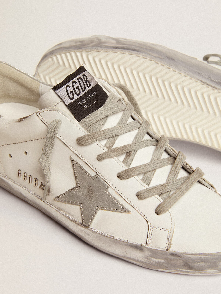 super-star feminino com detalhes prateados brilhantes e letras em tachas metálicas.
