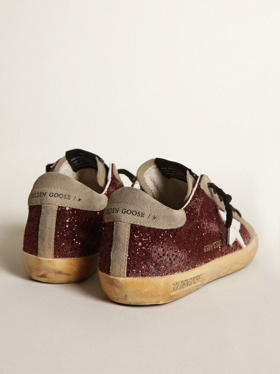 super-star feminino em glitter bordô com estrela de couro branco e língua de camurça cinza-pombo.