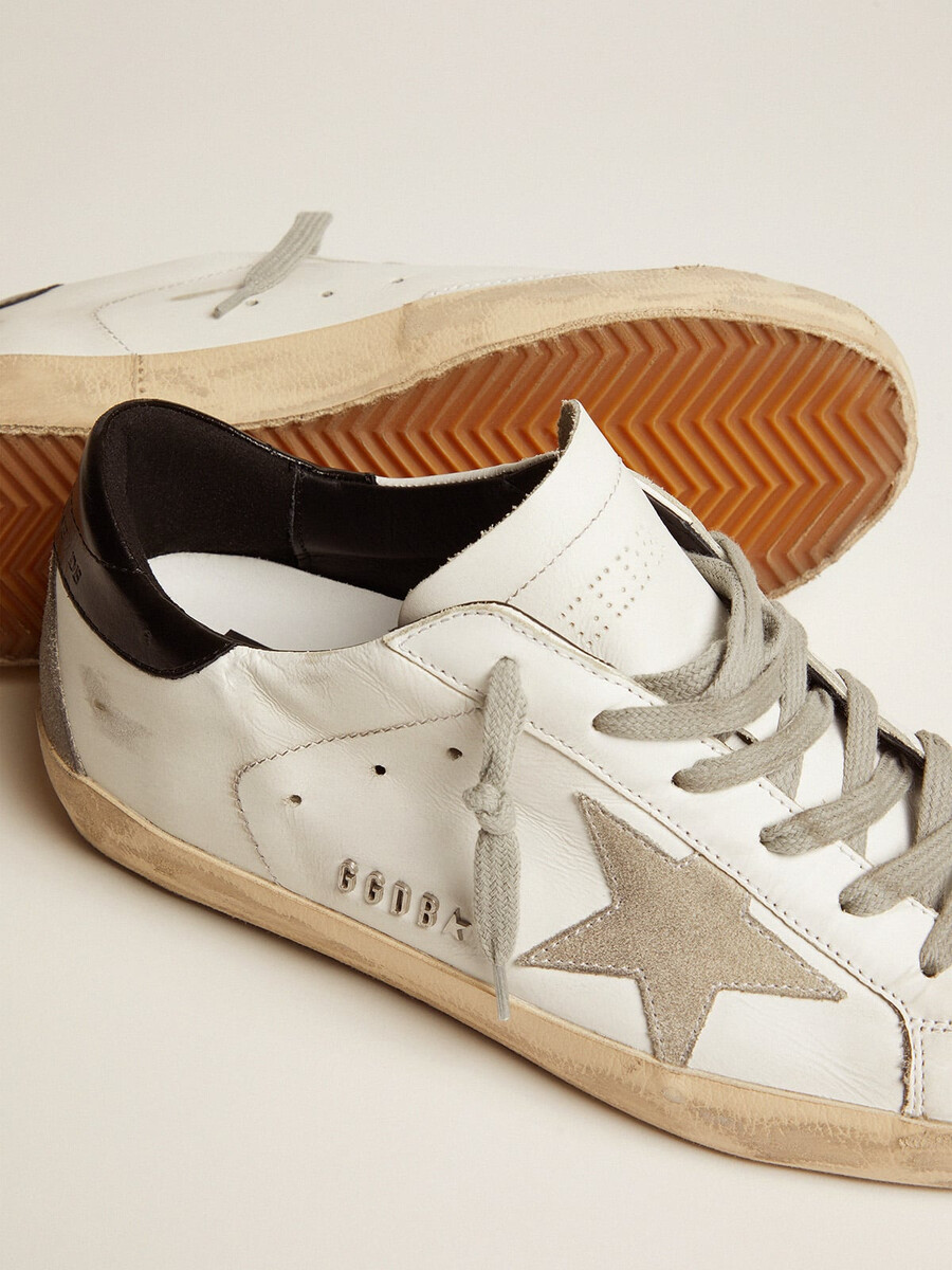 super-star feminino com detalhe preto no calcanhar e inscrição em tachas metálicas.