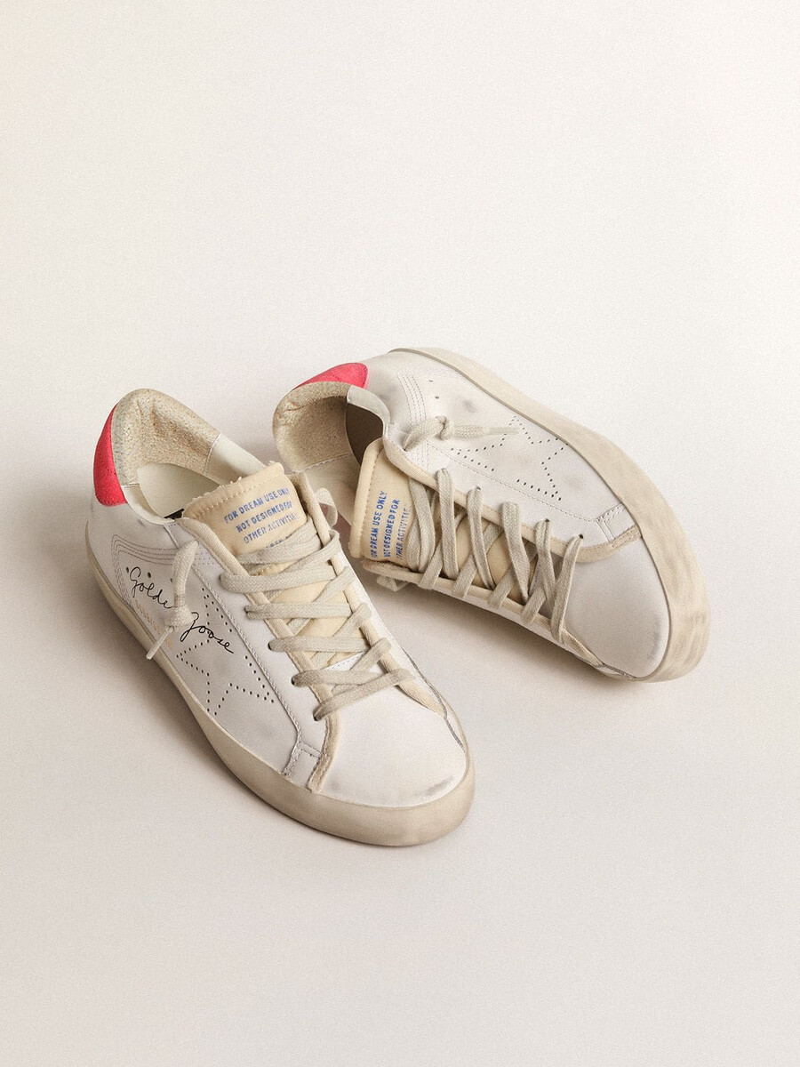 sapatilha feminina super-star em couro branco com estrela perfurada e detalhe em nylon fúcsia no calcanhar.