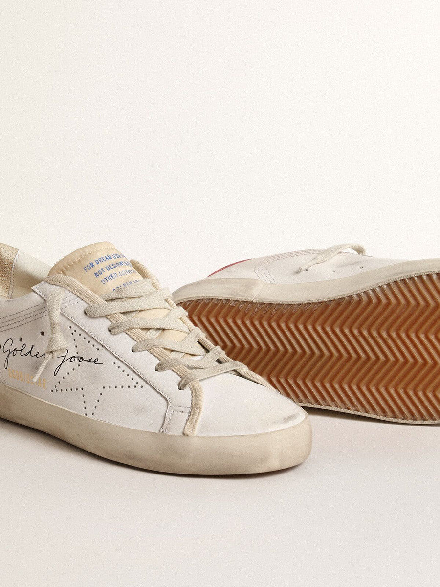 sapatilha feminina super-star em couro branco com estrela perfurada e detalhe em nylon fúcsia no calcanhar.