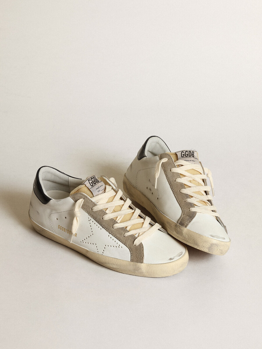tênis super-star feminino com estrela perfurada e detalhe azul-marinho no calcanhar.