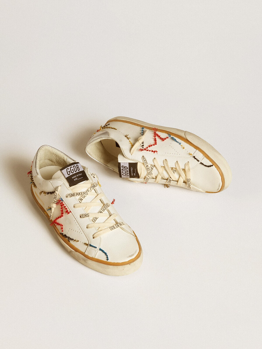 tênis feminino super-star ltd com estrela perfurada e detalhe em couro metalizado no calcanhar.