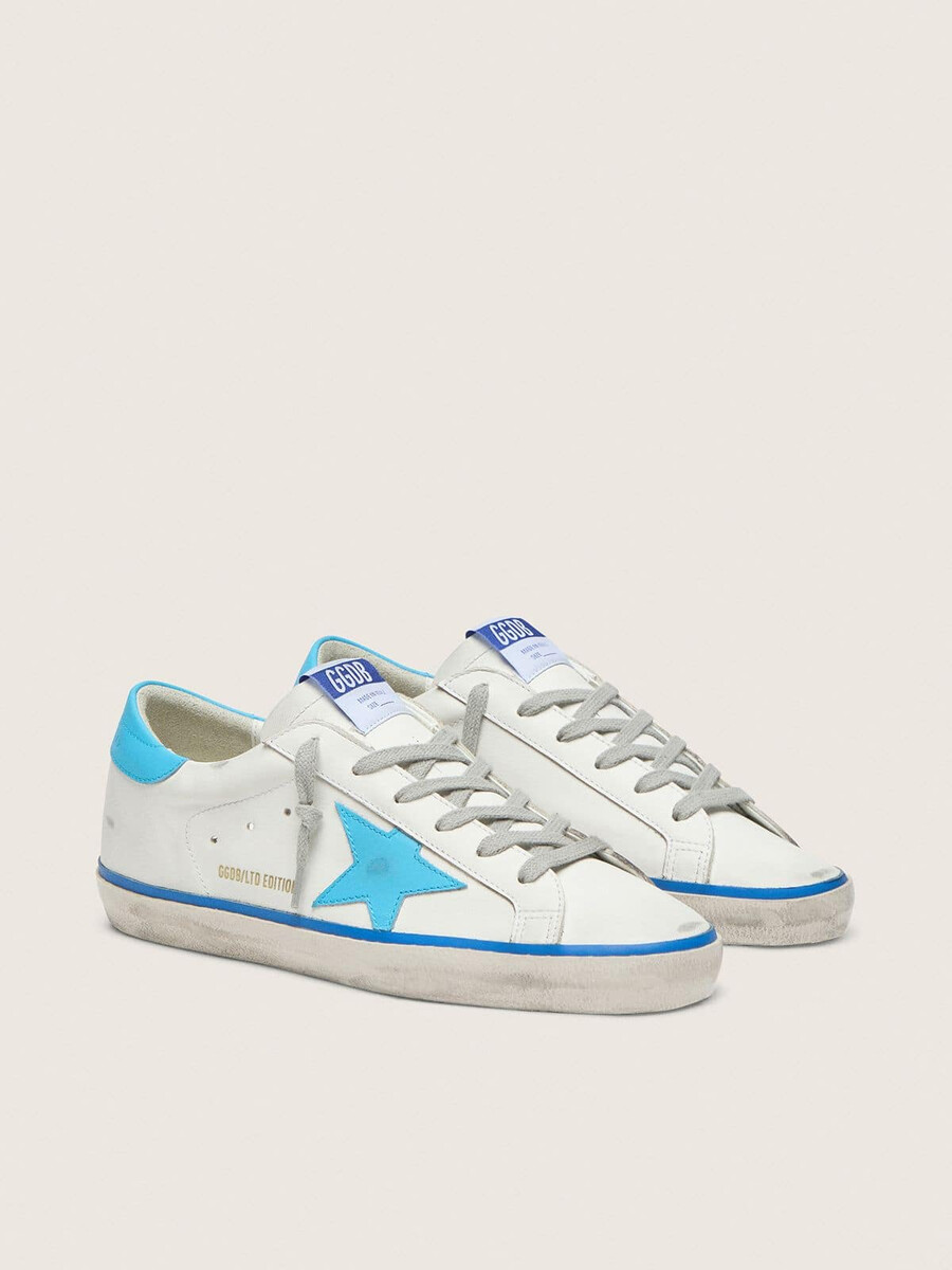 tênis super-star ltd feminino em couro branco com estrela em couro azul claro e detalhe no calcanhar.