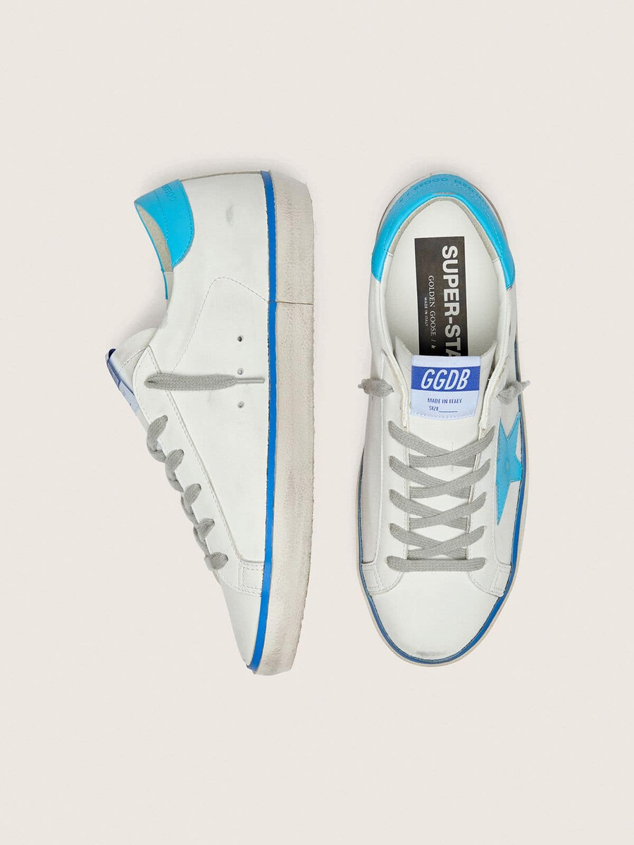 tênis super-star ltd feminino em couro branco com estrela em couro azul claro e detalhe no calcanhar.