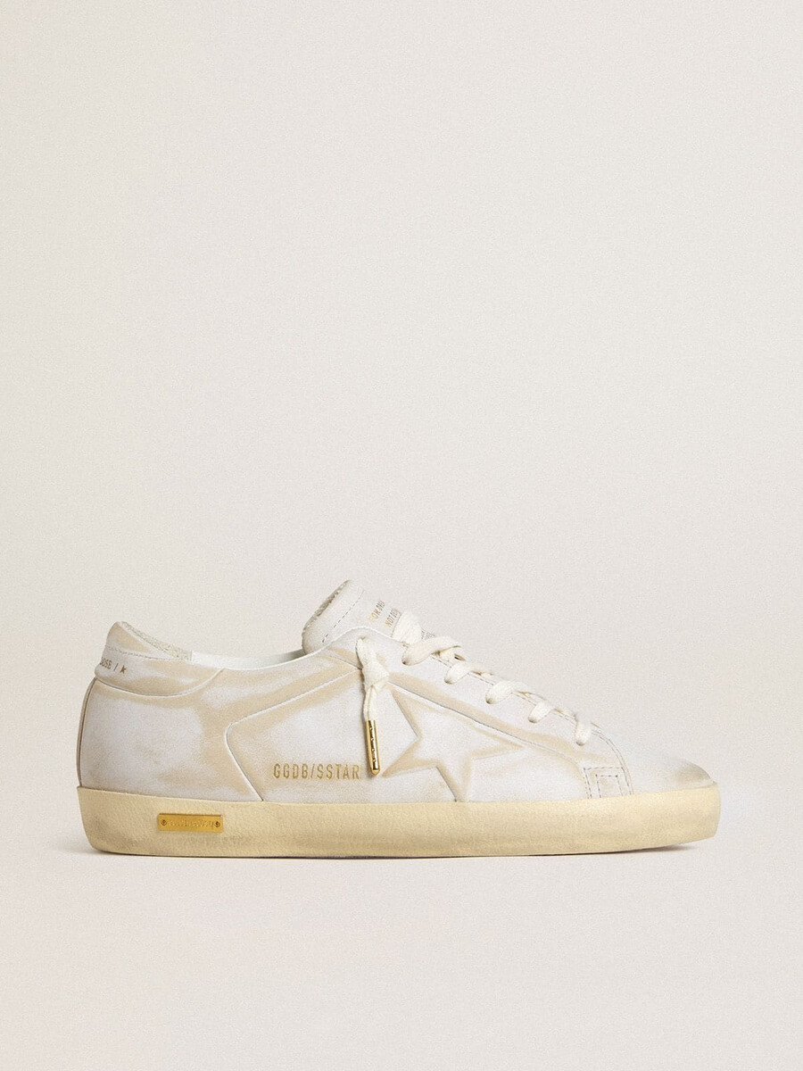 tênis feminino super-star com estrela de couro branco e detalhe no calcanhar com efeito desgastado.