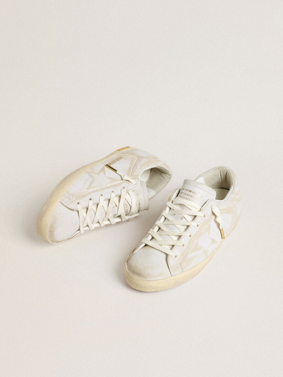 tênis feminino super-star com estrela de couro branco e detalhe no calcanhar com efeito desgastado.