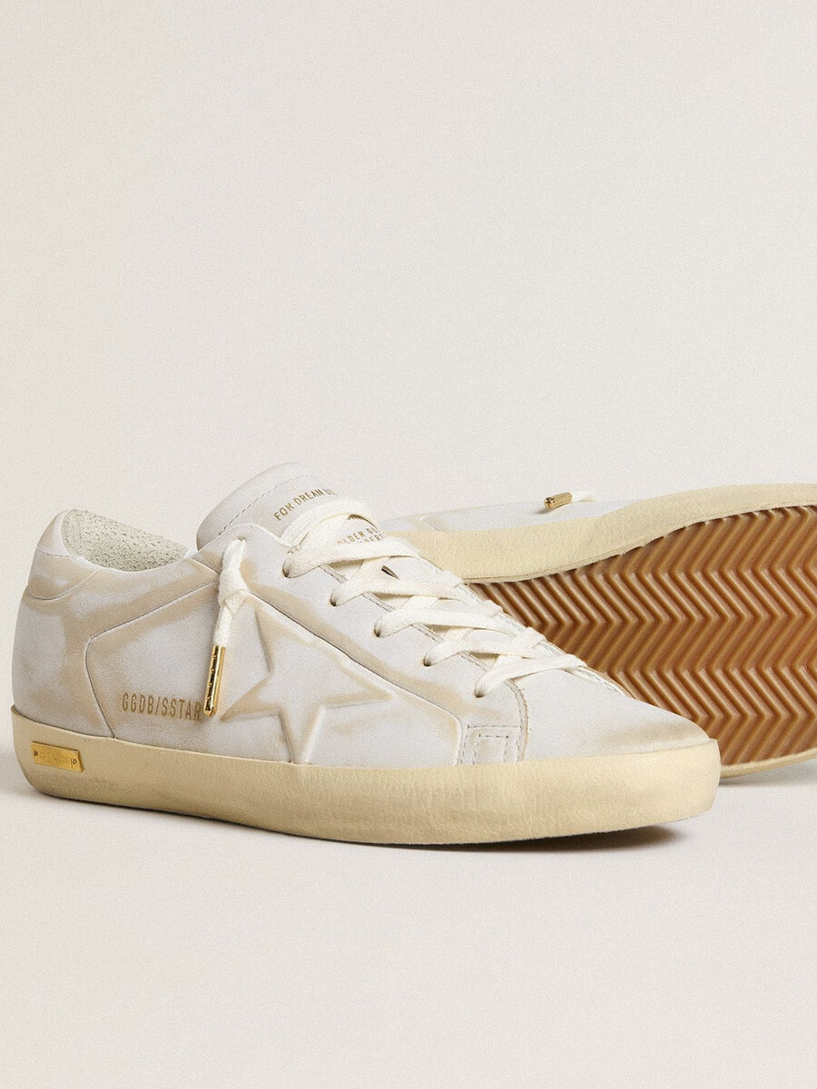 tênis feminino super-star com estrela de couro branco e detalhe no calcanhar com efeito desgastado.