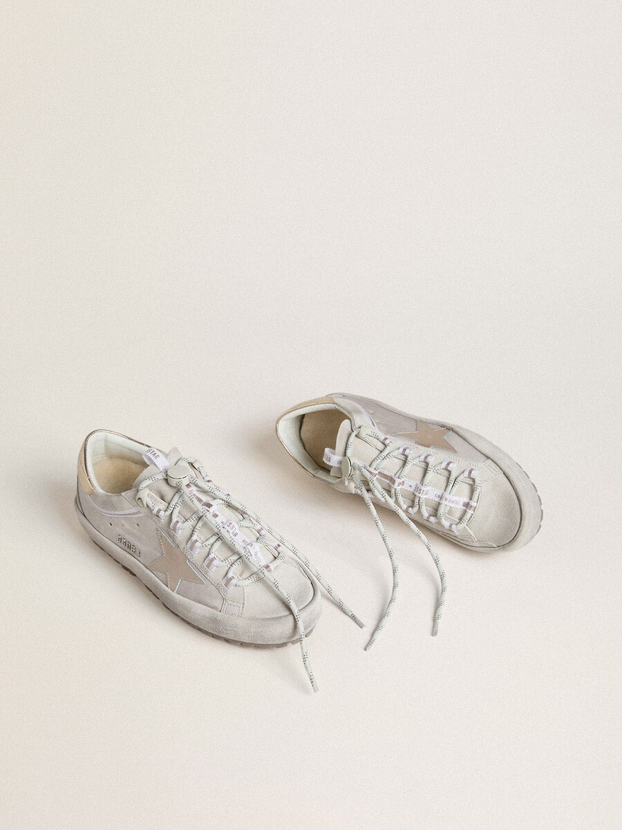 esqui feminino super-star em nylon cinza claro com estrela em couro metálico e detalhe no calcanhar.