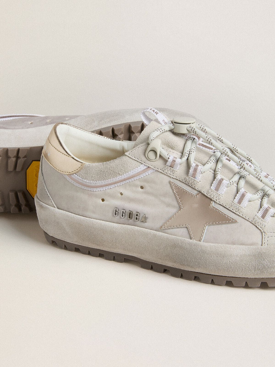 esqui feminino super-star em nylon cinza claro com estrela em couro metálico e detalhe no calcanhar.