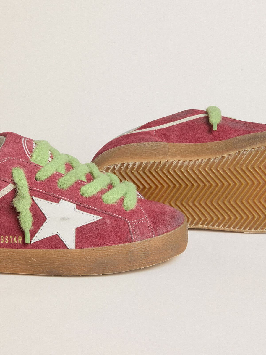 tênis super-star feminino em camurça vermelha com estrela de couro branco e detalhe de couro prateado no calcanhar.