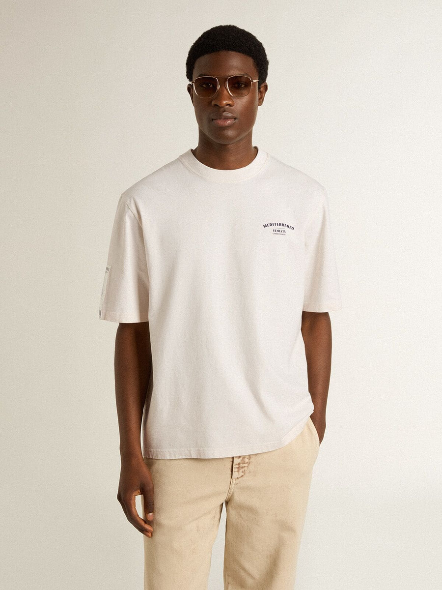 camiseta branca unissex com estampa mediterrânea e patch dourado da pescheria na manga.