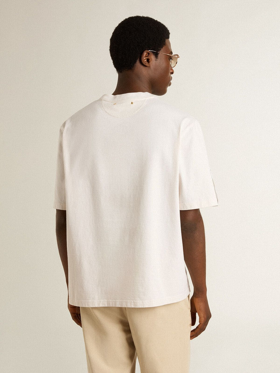 camiseta branca unissex com estampa mediterrânea e patch dourado da pescheria na manga.