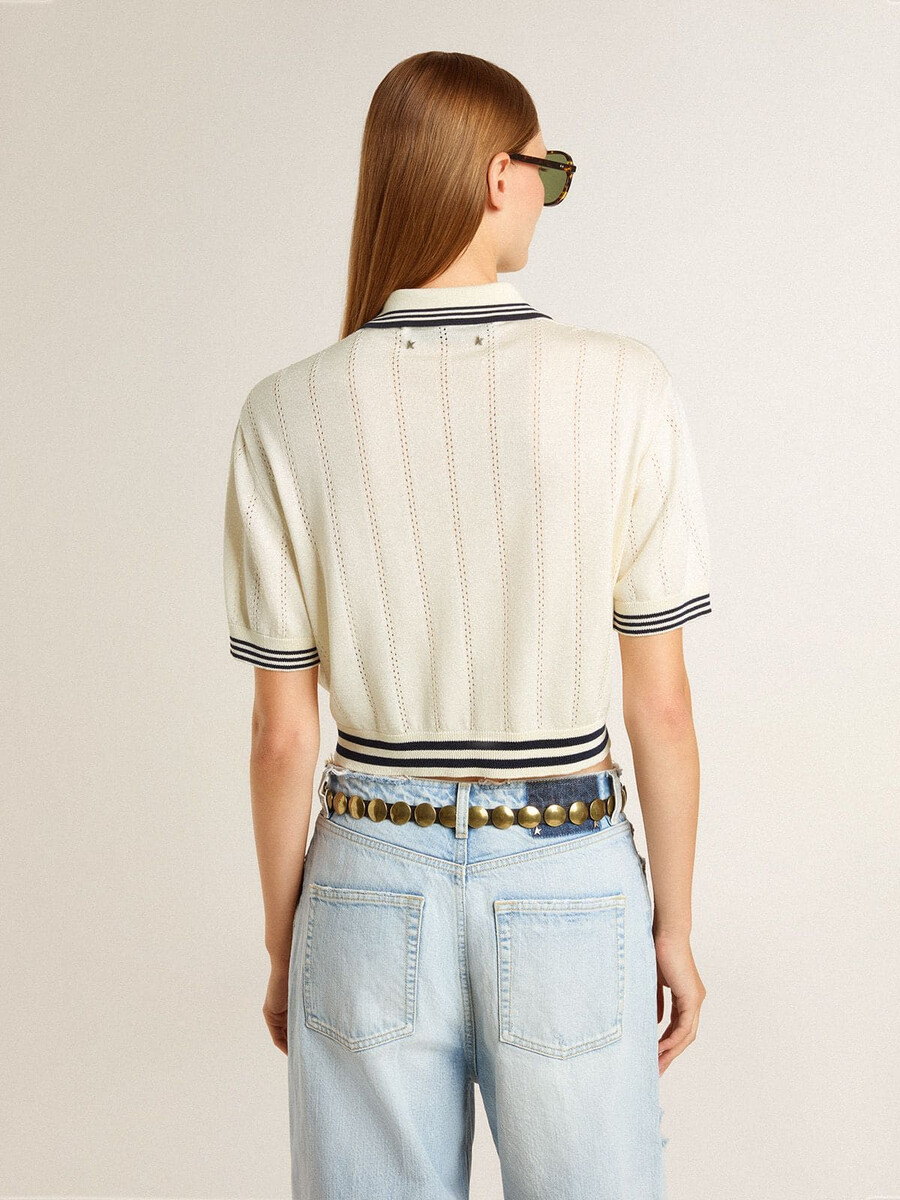 camisa polo feminina cropped em algodão branco desbotado com detalhes canelados azuis.